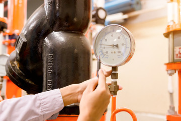 Engineer checking Condenser Water pump and pressure gauge , chiller water pump with pressure...