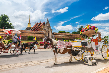 Tradition horse drawn retro carriage for traveler in front of Wat Phra That Lampang Luang, Attraction famous landmark tourist travel Lampang Thailand vacation trip, Tourism beautiful destinations Asia - obrazy, fototapety, plakaty