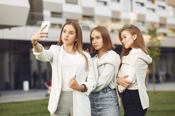 Students in a park. Girls on a campus. Friends with a phone.