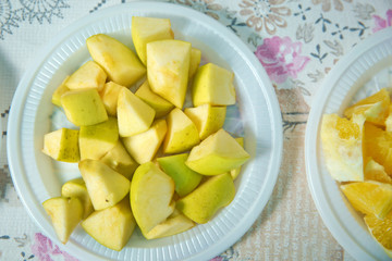 Cut quince in a plastic bowl. The chopped quince is in a plastic bowl .