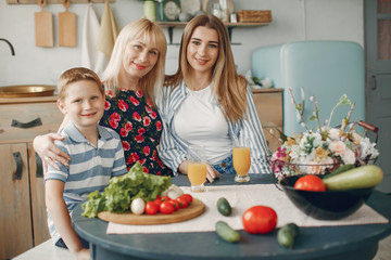 F in a kitchen. Blonde in a white t-shirt. Woman with vegetables