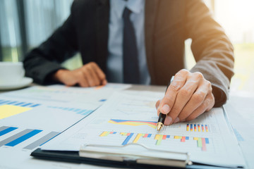 Business people partner negotiating a contract, they are pointing on a document and discussing together,Two businessmen are negotiating in office.