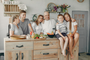 Family in a kitchen. Grandparents with grandchildren. People with vegetables