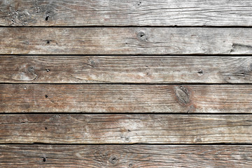 Obraz premium Close-up of wooden wall of rural house. Old, dry, weathered boards with deep cracks, with rusty nails driven in. Texture of wood. Abstract background. For design. empty template