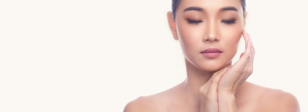 Beautiful Young Asian Woman with Clean Fresh Skin isolate on white background. Spa, Face care, Facial treatment, Beauty and Cosmetics concept. Right hand touch chin. Eye close. Banner frame.