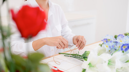 Flower shop staff arrange flowers as ordered for valentines.