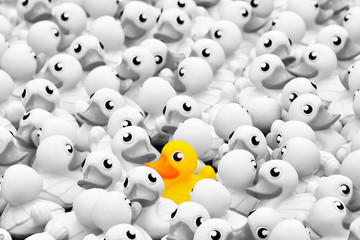 Unique yellow toy duck among many monochrome ones. Standing out from crowd, individuality and...