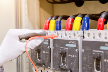 Technician is measuring voltage or current by voltmeter in control panel of power plan with...