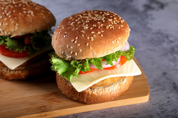 Fast Food - Burgers on a wooden mat with textured background