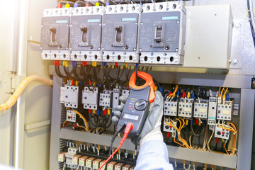 Electrician measuring voltage in distribution board, closeup