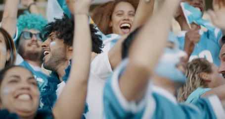 Spectator in stadium celebrating victory their team's victory. Argentina football supporters cheering and jumping in unison at stadium.