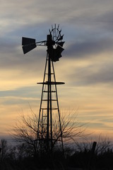 Kansas Windmill at Sunset with a colorful sky out in the country north of Hutchinson Kansas USA.