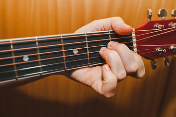 light-skinned hand holds a am chord on a six-string guitar. Learning to play the guitar, lifestyle...