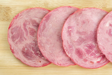 Slices of sliced ham on the kitchen Board close-up.