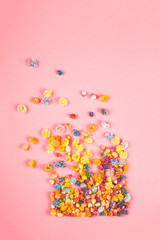 Creative spring layout square of many small nazokolotnyh flowers that fly out on a pink background.