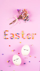 Easter creative layout with the word Easter made of flowers, a bouquet of small flowers and cute white eggs with closed eyes on the lilac.