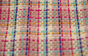 Abstract multicolor cloth texture, close up fashion background. Multicolored plaid tweed fabric.