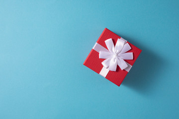 Valentine's Day celebration concept. A nice gift from a loved one. Box with a bow on a gentle blue background. Copy space. Flat lay. Close-up.