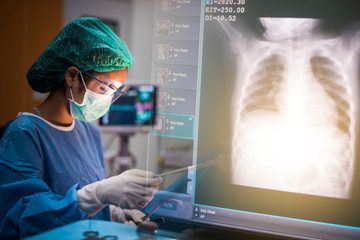 team of surgeons working in the operating room with lung x ray film, medical concept	 - Powered by Adobe