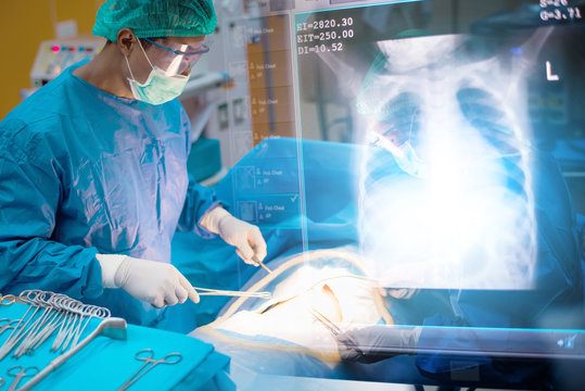 Team Of Surgeons Working In The Operating Room With Lung X Ray Film, Medical Concept	