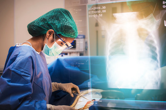 team of surgeons working in the operating room with lung x ray film, medical concept - Powered by Adobe