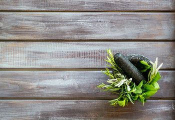 Herbs in ceramic mortar with pestle on dark wooden backgroud top-down copy space