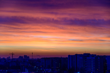 Fototapeta premium Photo of a dark sky over the city in the early autumn morning with colorful clouds