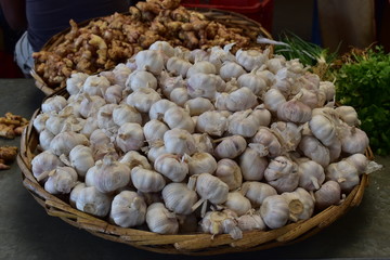 Pile of garlic heads in a rustic basket for sale.  Healthy food bacground. Picture from a morning market.
