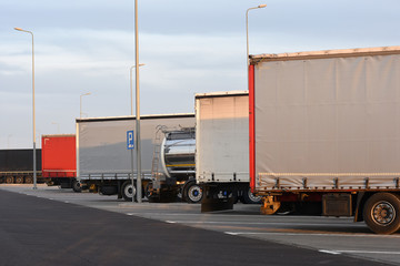 Side view of many trucks staying on rest area