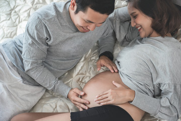 Couple happiness in love pregnant. Pregnant woman enjoying with husband touch belly in bed at home. Romantic moments for relationship of pregnant couple. Waiting for baby, Time of hope