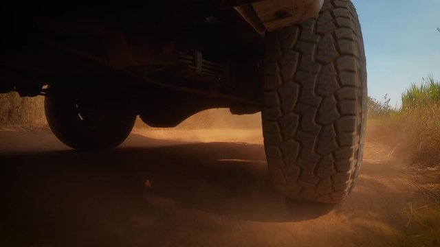 The rear wheels powertrain system of the 4 wheels off road drive light truck driving on dirt and dust ground