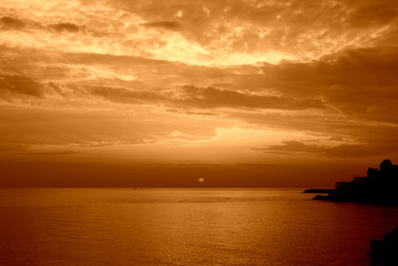 Naklejka na ściany i meble Beautiful sunrise over the sea near the coast of Sicily. Natural background orange color toned