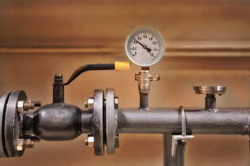Gauge closeup, pressure measurement . Pipes and valves in the industrial enterprise.