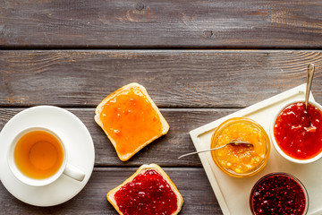 Tea party with jam. Toast, teapot, cup on dark wooden background frame copy space