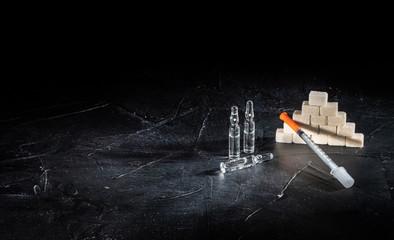 Bottle of insulin for diabetes and injection syringe, healthcare concept with refined loaf sugar...