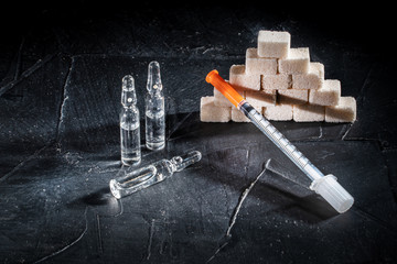 Bottle of insulin for diabetes and injection syringe, healthcare concept with refined loaf sugar...