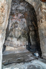 Buddha statue carved in a cave. Figure in Wei style grotto at Longmen Grottoes, Henan province,...