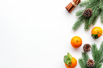 Tangerines near fir branches. New Year composition on white background top-down frame copy space