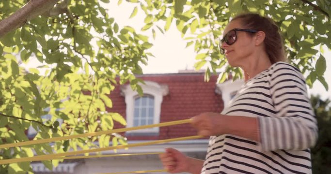 MS Senior Woman Exercising on Garden Lawn, as Senior Men Leads Her to Home. Shot in R3D (6K RED RAW)