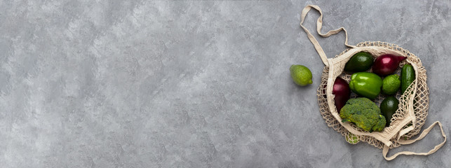 Shopping bag with vegetables on a concrete background, banner