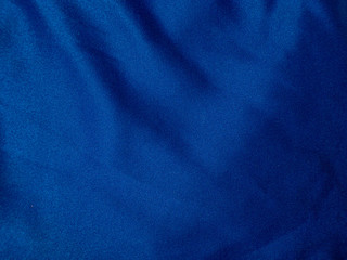 Fototapeta na wymiar Texture and background of blue fabric. Fabric with pleats and waves. Material for sewing.