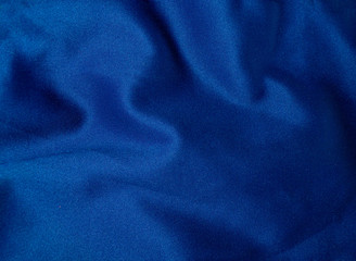 Background texture of the fabric. Blue silk. Silk fabric with pleats and flounces. Background and texture of fabric and sewing material.