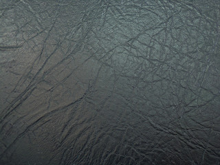 The texture of the black leather fabric. Background and texture of the leather upholstery of the...