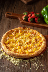 whole italian pizza on wood table with ingredients