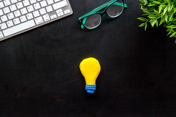 Insight, inspiration concept. Light bulb on black office desk top-down copy space
