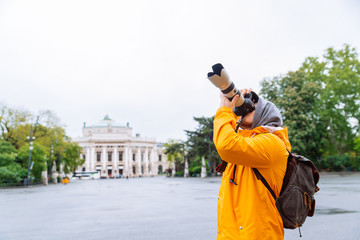 man with professional camera and big lens taking picture of the city architecture