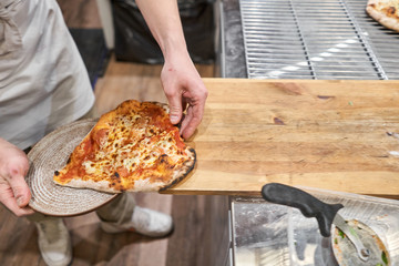 Pizza Margarita Heart-shaped for Valentine's day.. Baked tasty margherita pizza in Traditional wood oven in Neapolitan restaurant, Italy.