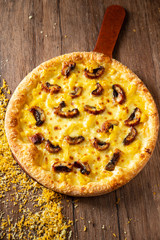 whole italian pizza on wood table with ingredients