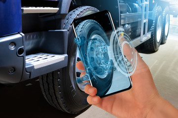 Serviceman repairing a truck using augmented reality application.	