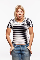 Obraz premium Young blond woman in jeans screaming. White background. Vertical.